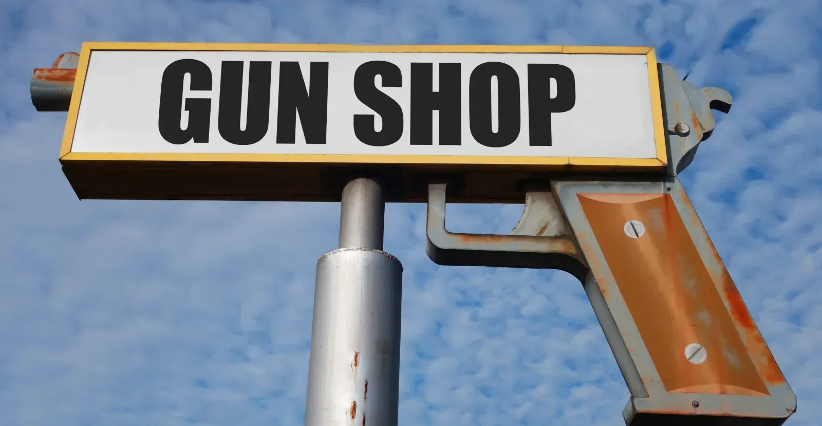 Gun shop sign in the shape of a handgun