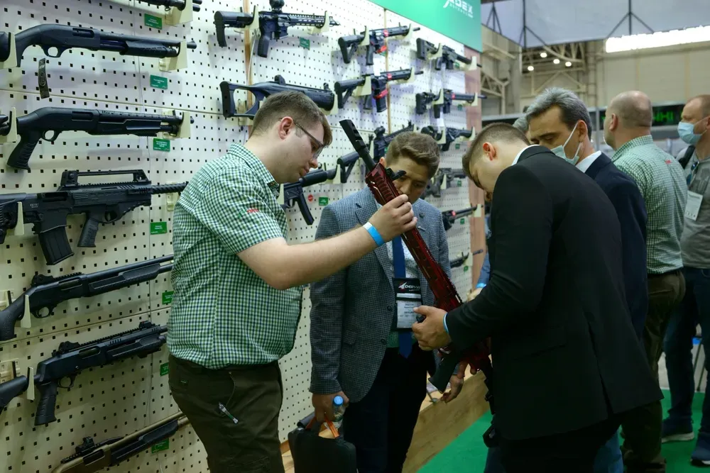 two people looking at a gun in a gun store with employee
