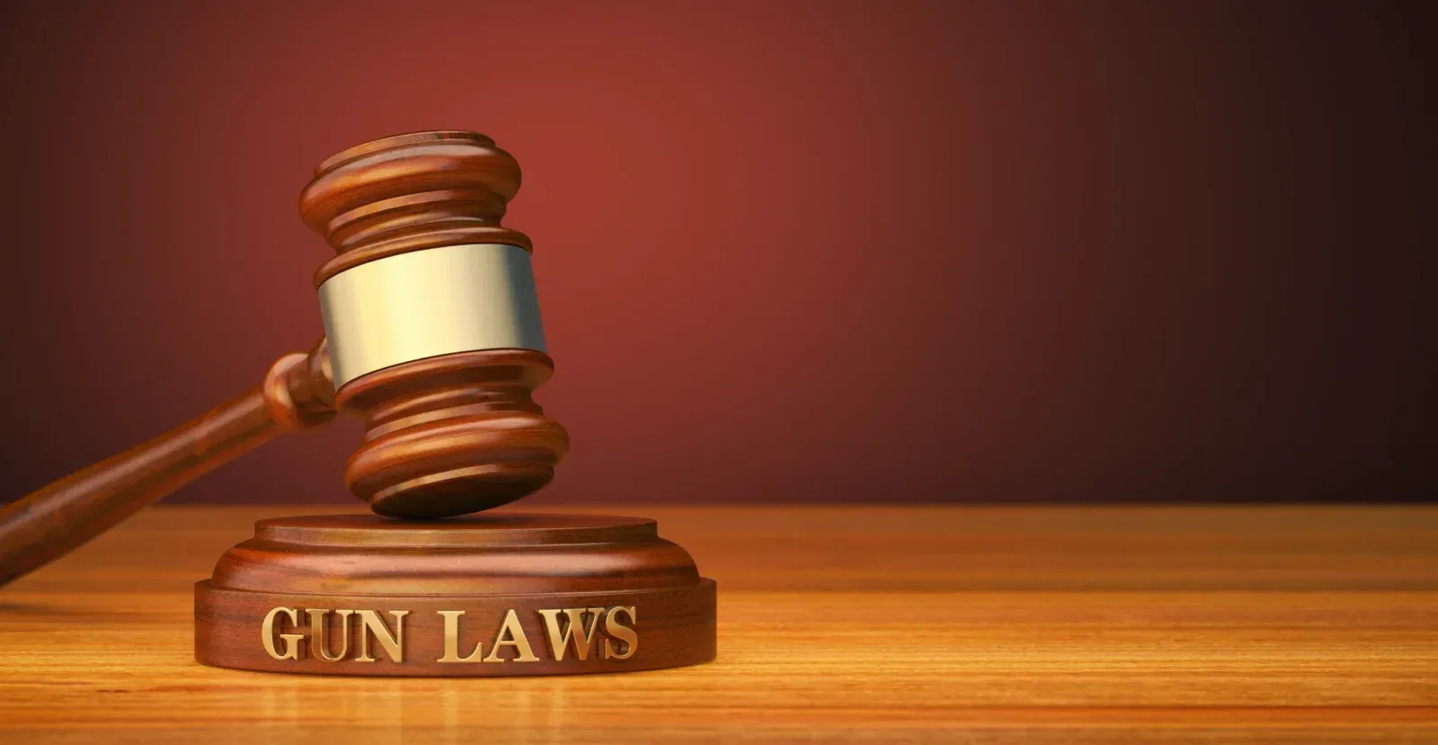 A gavel striking a gavel block that says Gun Laws