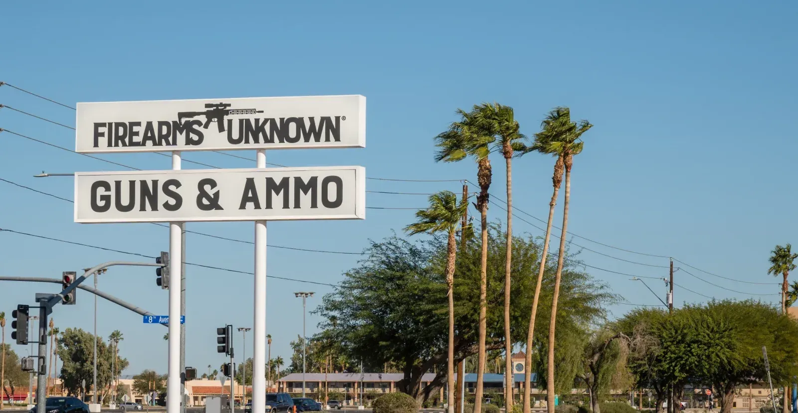 Road sign that says "Firearms Unknown" "Guns & Ammo"