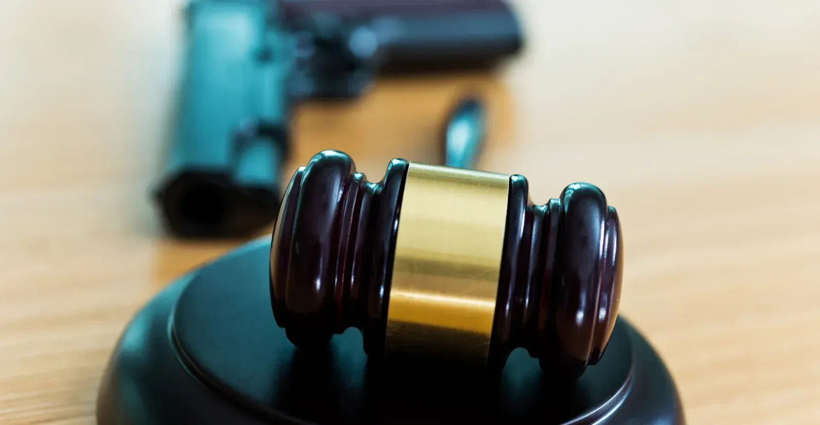 Gavel with a gun behind it