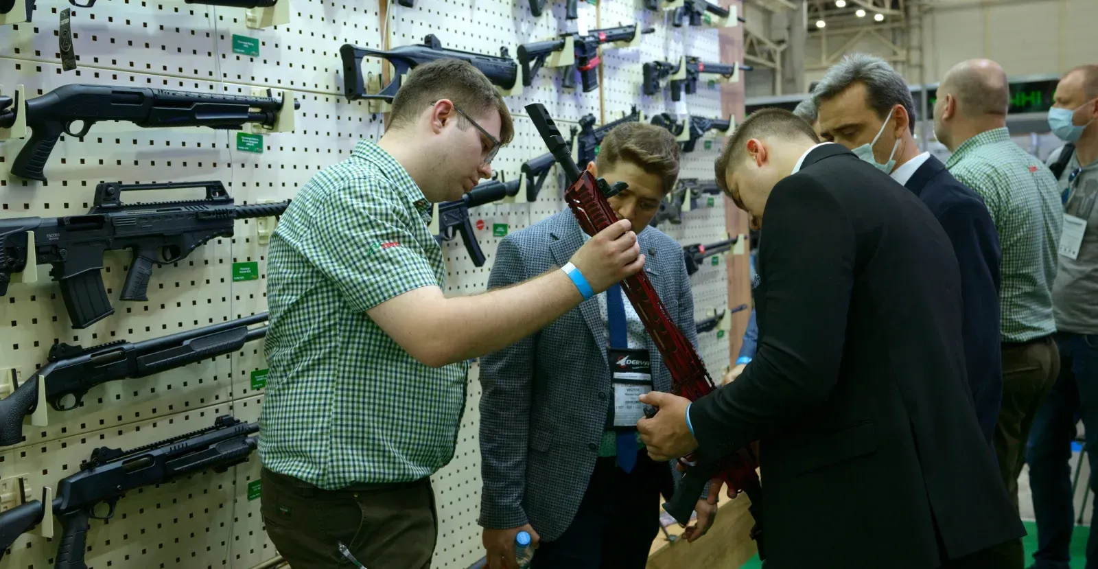People in a gun store looking at a gun