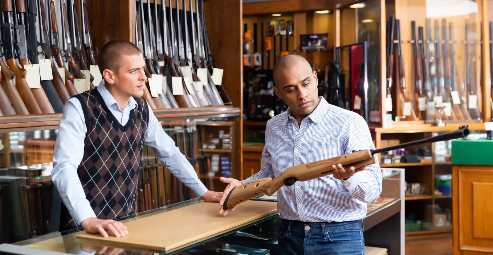 a man looking at a rifle in a store