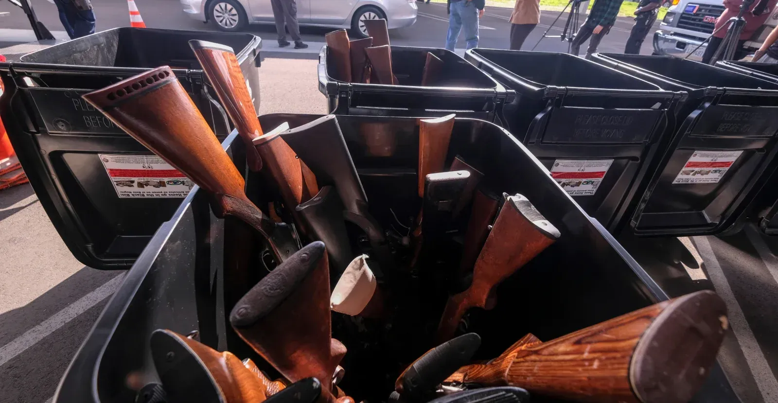 Several guns piled into a bin