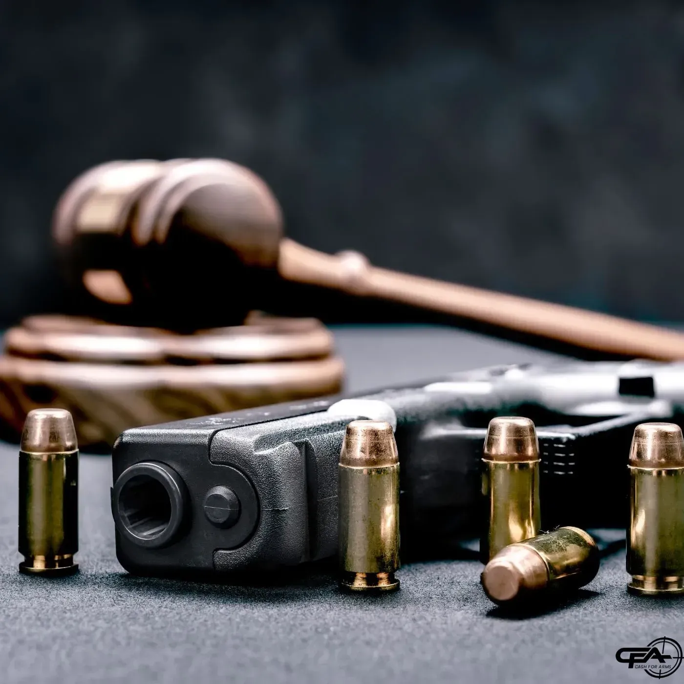 Gun and ammo with a gavel in the background