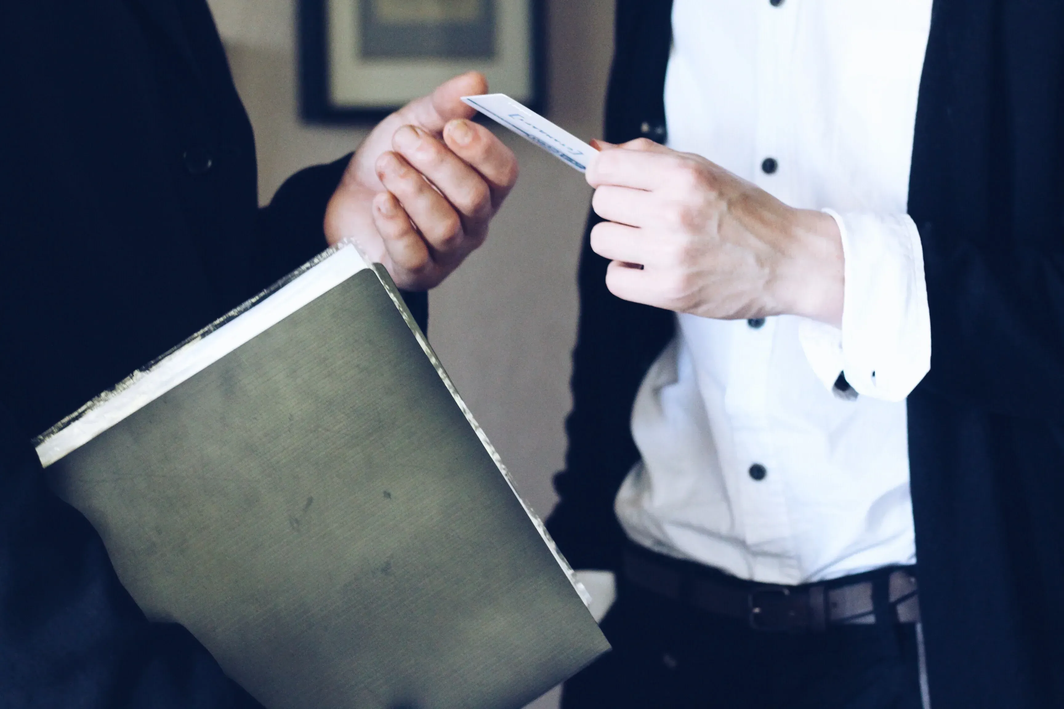 A man handing a card to another person