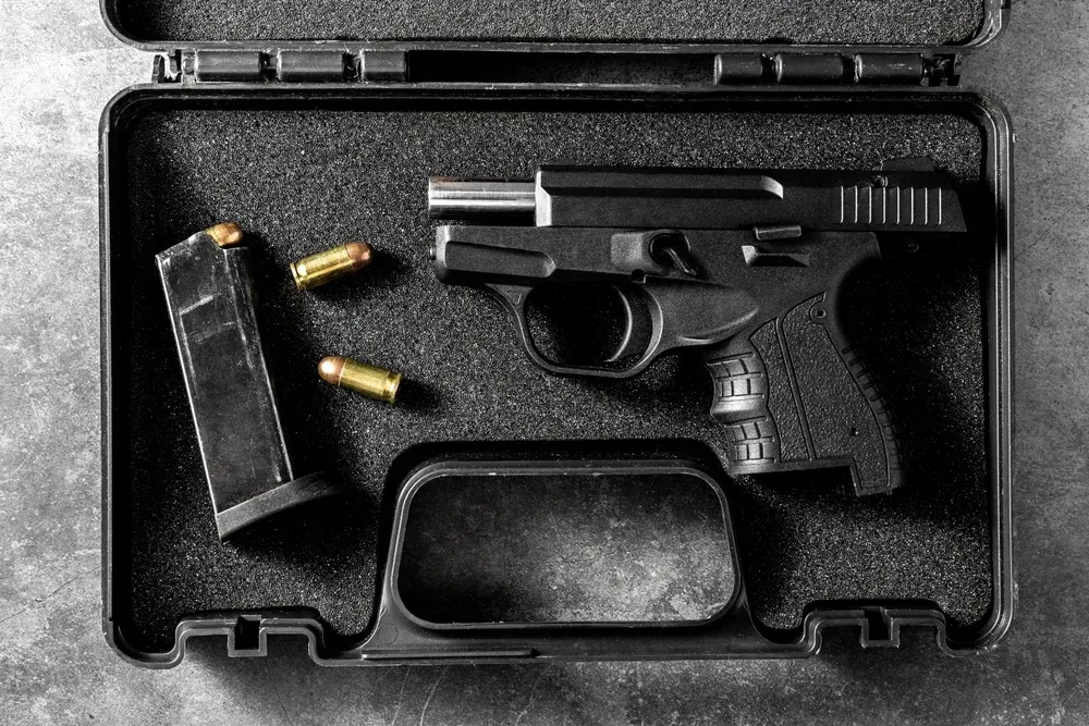A gun inside a case with bullets and magazine out