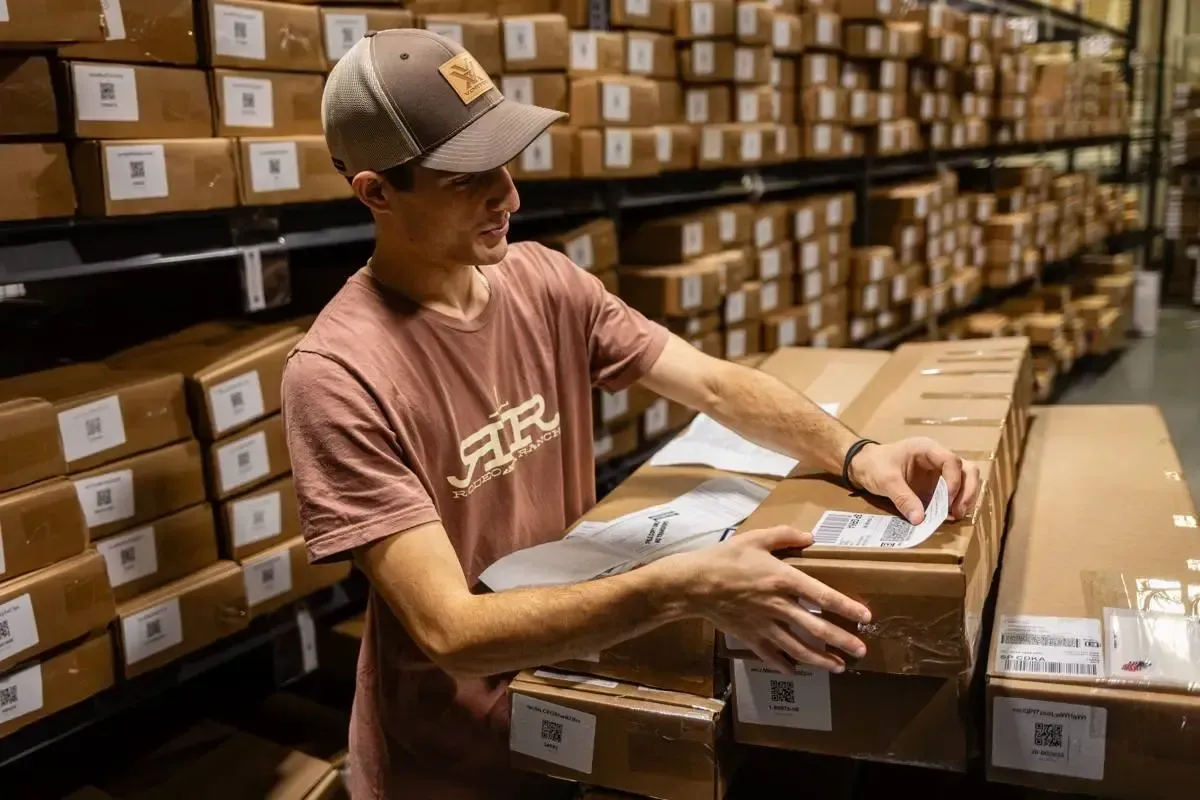 Cash for Arms staff processing an incoming rifle shipment inside the licensed HQ warehouse
